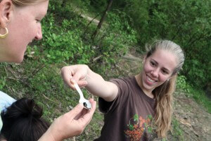 Savannah Long shows Casey a tadpole she collected in a water sample at Chicopee Lake. 