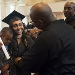Nilka Clayton, center, listens to advice from her uncle William Clayton as she holds her cousin Triston Derricotte after Saturday's graduation services.