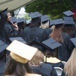 Adrienne Reed, left, waves to the crowd of friends and family that came out to support their graduating seniors in the rainy weather Friday.