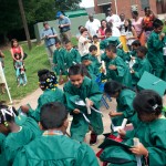 Children from the RISE program run back to their seats after throwing their hats during the RISE graduation at the Davis Street Community Center, 850 Davis Street, in Gainesville.