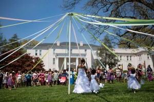 Members of the May Court prepare to weave around one another to wrap the Maypole while the May Queen, Brenau senior Lea Mason, stands at the center.