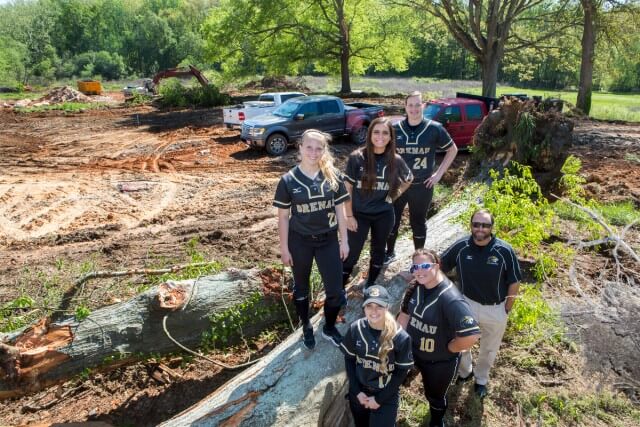 Top from left, Mason Garland, Allison Gunn and Elizabeth Schneider. Bottom from left, Madison Strickland, Kathrine Cole and coach Devon Thomas. Members of the Golden Tigers Softball Team pose for a portrait on the site of the new Ernest Ledford Grindle Athletics Park.