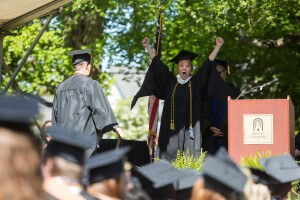 Brenau Professor of Occupational Therapy Jenene Craig cheers from the stage during the 2015 Undergraduate and Graduate Commencement