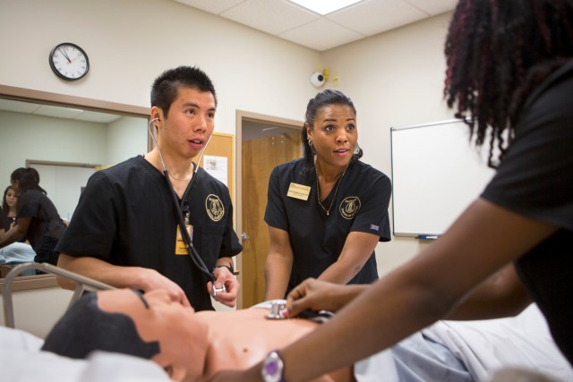 Nursing professor Melissa McDowell helps senior nursing student Sam Ung and junior nursing student Marie Lacossiere as they run though an assessment on the iStan simulator.