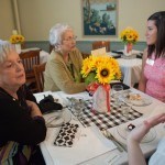 Susan Moody Stevens, WC '66, bottom and Mary Ann Griner Mulligan, WC '66, speak with Hanah Vigil-Shuck, a junior psychology major, and Allie Smith, a junior mass communications major, respectively at the 24 Karat Gold Club & Golden Roses Tea on Friday, April 15, 2016, in Gainesville, Ga. (AJ Reynolds/Brenau University)