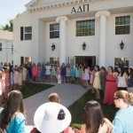 Members of Alpha Delta Pi stand locked in arms singing on the lawn during Sorority Open House.
