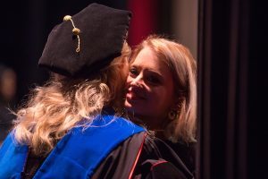 Marcie Nicole Nicks hugs Dina Hewett, director of the School of Nursing, after being hooded for a Master of Nursing degree during the Brenau University College of Health Sciences Graduate Hooding Ceremony on Thursday, May 5, 2016. (AJ Reynolds/Brenau University)