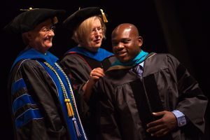Dr. Allen Patmon is hooded for an Occupational Therapy Doctorate by Gale Starich, dean of the College of Health Sciences, and Barbara Schell, associate dean of the College of Health Sciences, during the Brenau University College of Health Sciences Graduate Hooding Ceremony on Thursday, May 5, 2016. (AJ Reynolds/Brenau University)
