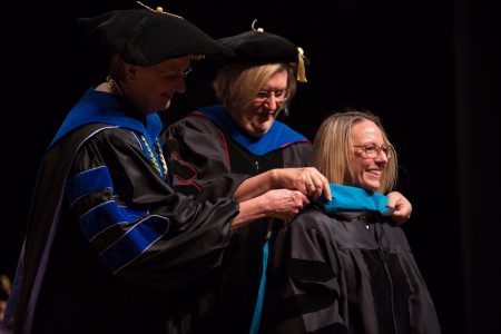 Dr. Sara Propes is hooded for an Occupational Therapy Doctorate by Gale Starich, dean of the College of Health Sciences, and Barbara Schell, associate dean of the College of Health Sciences, during the Brenau University College of Health Sciences Graduate Hooding Ceremony on Thursday, May 5, 2016. (AJ Reynolds/Brenau University)