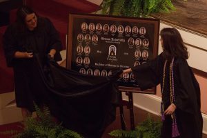 Lindsey Smith and Lauren Gooch unveil the class composite during the Brenau University School of Nursing Pinning Ceremony on Thursday, May 5, 2016 in Pearce Auditorium in Gainesville, Ga. (AJ Reynolds/Brenau University)