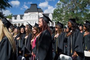 Graduates place their hands on their hears during the singing of the National Anthem during The Women's College commencement on Friday, May 6, 2016, in Gainesville, Ga. (AJ Reynolds/Brenau University)