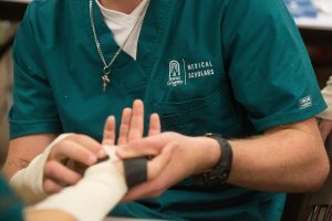 TJ Wolcott puts a splint on Ansley Rochester's hand while working in the occupational therapy specialization during the final day of the first Brenau Medical Scholars Program at Brenau University East Campus on Wednesday, April 13, 2106, in Gainesville, Ga. (AJ Reynolds/Brenau University)