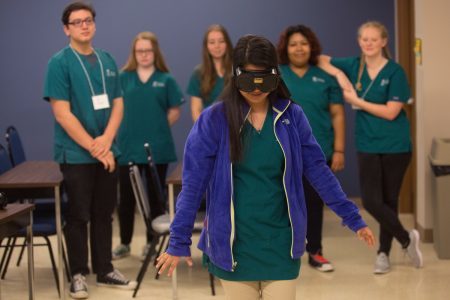 Leslie Espinoza attempts to navigate a course while wearing goggles simulation alcohol intoxication during the psychology specialization during the final day of the first Brenau Medical Scholars Program at Brenau University East Campus on Wednesday, April 13, 2016, in Gainesville, Ga. (AJ Reynolds/Brenau University)