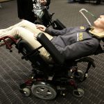 Brenau University occupational therapy graduate student Lauren Tomy discovers how lean back a "Sip & Puff Power Wheelchair" by blowing on a straw. (Phil Skinner for Brenau University)