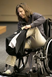Brenau University occupational therapy graduate student Becca Fiscal attempts to put shorts on in a wheelchair without using any leg muscles or leg strength. This exercise simulated what a patient may encounter. (Phil Skinner for Brenau University)