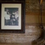 A portrait of Joyce Lott, WC '59, and her husband Tom Lott hangs inside their cabin at their farm. The cabin was the first building the couple built on their property, which led to the rest of the antique village. (AJ Reynolds/Brenau University)
