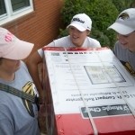 From left to right, Olivia Davis, Morgan Wood and Lauren Smith work together to carry a mini refrigerator into the residence halls. (AJ Reynolds/Brenau University)