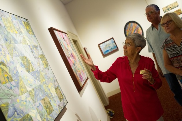 Docent points out details in painting to visiting patrons.