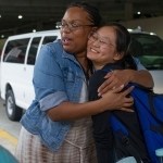 Daisy Qiu get a hug from Dr. Crystal Toombs, associate provost for adult and graduate studies, before boarding a bus to leave the airport. (AJ Reynolds/Brenau University)