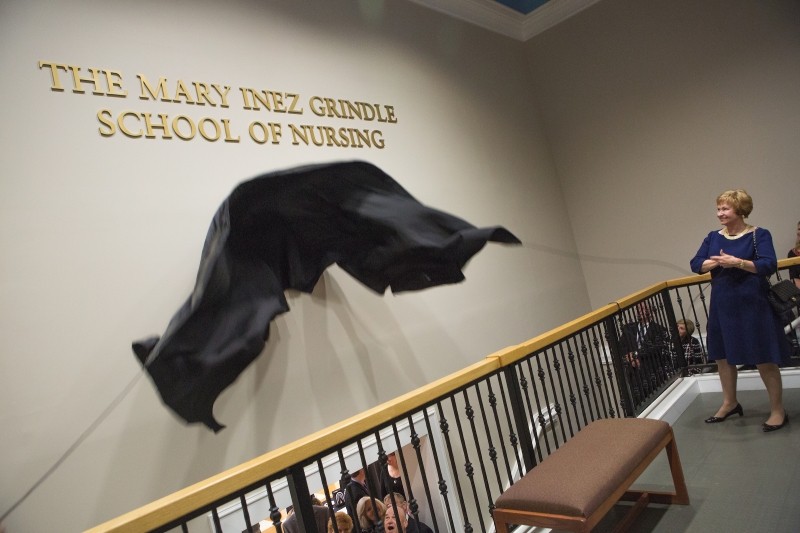 Kay Ivester removes the covering from the sign for the Mary Inez Grindle School of Nursing during the dedication of the Mary Inez Grindle School of Nursing. (AJ Reynolds/Brenau University)