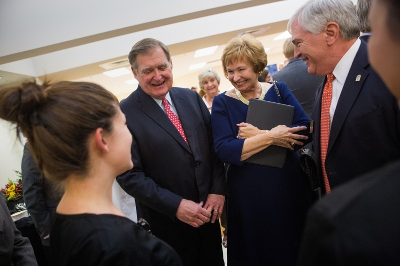 From left to right, Douglas Ivester, Kay Ivester and Brenau President Ed Schrader react to seeing the new scrubs for students of the Mary Inez Grindle School of Nursing during the dedication of the Mary Inez Grindle School of Nursing. (AJ Reynolds/Brenau University)