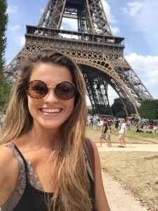 Madison Kosater poses for a photo near the Eiffel Tower.
