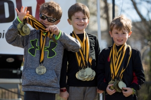 Will Dempsey, Maddox Dempsey and Cooper Dempsey present the medals after the Dempsey Dash 5K, a race celebrating the memory of Brenau's longtime Executive Vice President and CFO Wayne Dempsey, on Saturday, March 11, 2017. (AJ Reynolds/Brenau University)