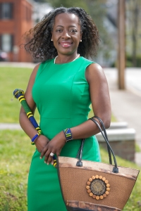 Margie Gill poses for a photo with an honorary warrior stick from Rwanda along with a purse and two bracelets gifted to her. (AJ Reynolds/Brenau University)