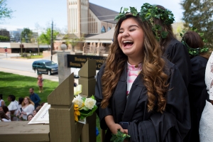 Nancy Benitez, a graduating senior, waits to pass her robe to a junior. (AJ Reynolds/Brenau University)