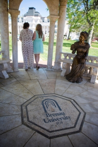 Sophomore Hannah Adams is escorted from the Daniel Pavillon by her mother Gina during the procession of the May Court. (AJ Reynolds/Brenau University)