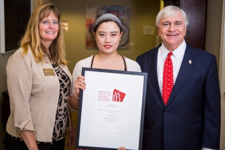 Lynn Jones, Qingyuan Julia Zhu and Brenau President Ed Schrader pose for a photo with Zhu's honorable mention from the American Society of Interior Designers