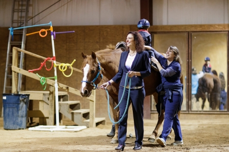 Nicole Walker, BU ’01, occupational therapist and owner of Walker Therapy in Gainesville, Georgia, leads a horse while fellow therapist Nolina Varley, BU ’01, helps make sure a client maintains his balance during an equine therapy session. (Photos by AJ Reynolds/Brenau University)