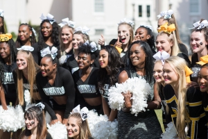 Terry Capers, BU '14 and winner of the Service to Brenau Award, poses for photos with a group of cheerleaders during the homecoming celebrations at Brenau University. (AJ Reynolds/Brenau University)