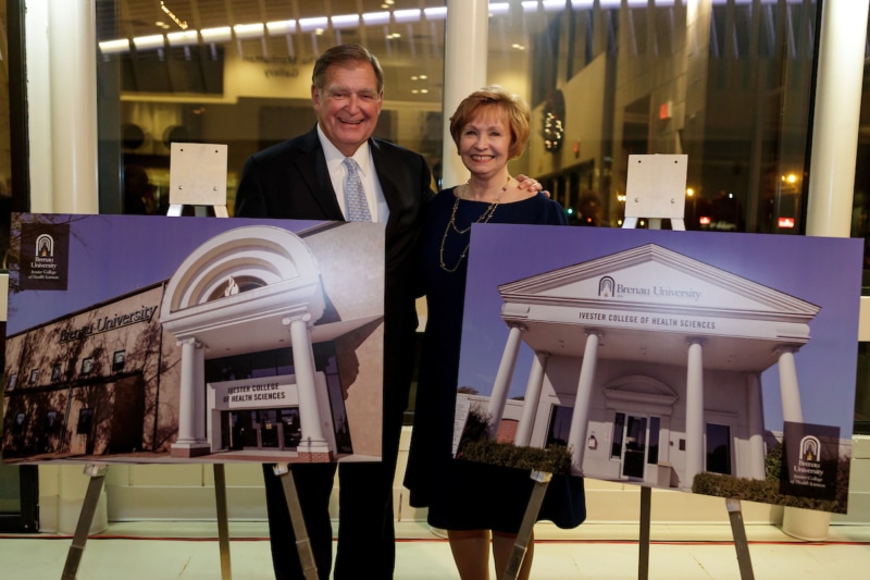 Doug Ivester and Kay Ivester pose for a photo next to a rendering of the Brenau East with the lettering of the Ivester College of Health Sciences during an event announcing the naming of the Brenau University Ivester College of Health Sciences. (AJ Reynolds/Brenau University)