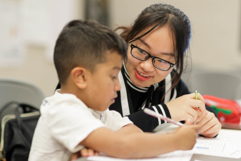 Youlanda Xuan Guan, an education student in a 2+2 partnership between Brenau and Anhui Normal University in China, works with a first grader at Fair Street International Academy on Friday, Feb. 2, 2018. (AJ Reynolds/Brenau University)