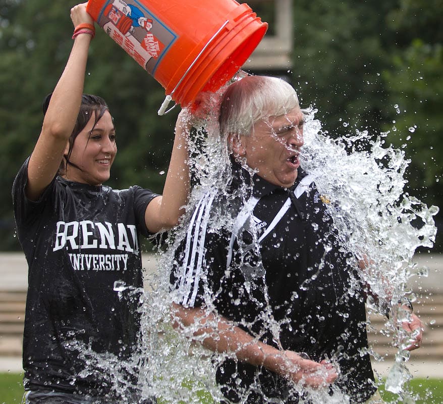 Brandelyn Nagy douses Brenau University President Ed Schrader with a bucket of ice water as she and the rest of the Brenau Competitive Cheer team and President Schrader take the ALS ice bucket challenge.
