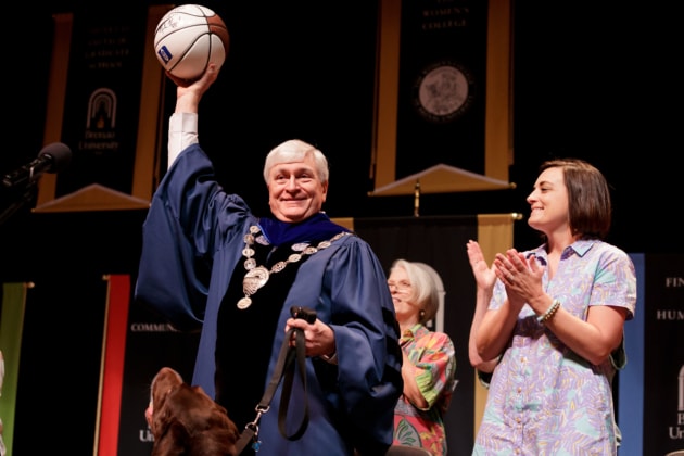 President Emeritus Ed Schrader holds up a basketball.