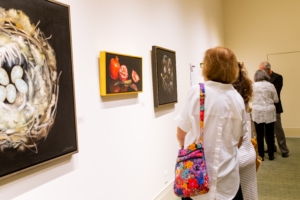 Attendees look at art during the President's Summer Art Series.